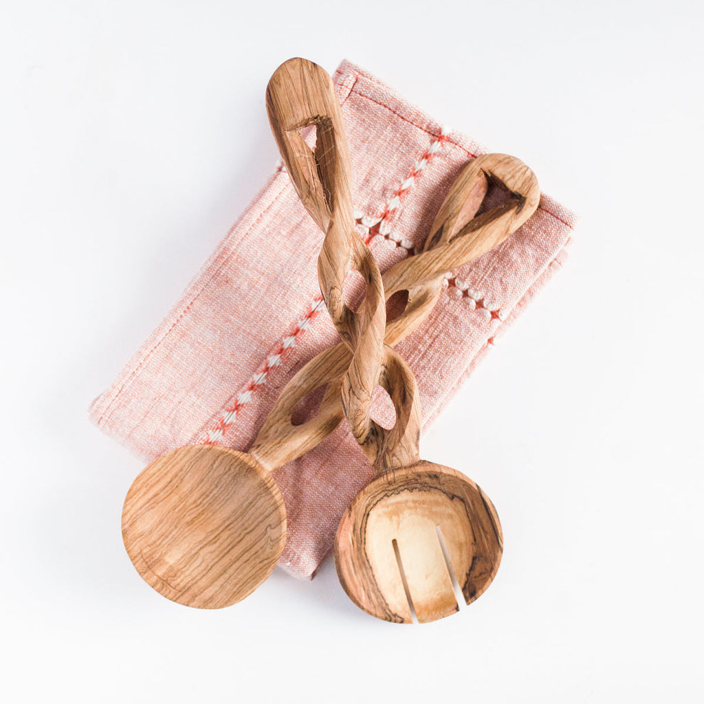 Wooden spoons with a pink cloth on a white background