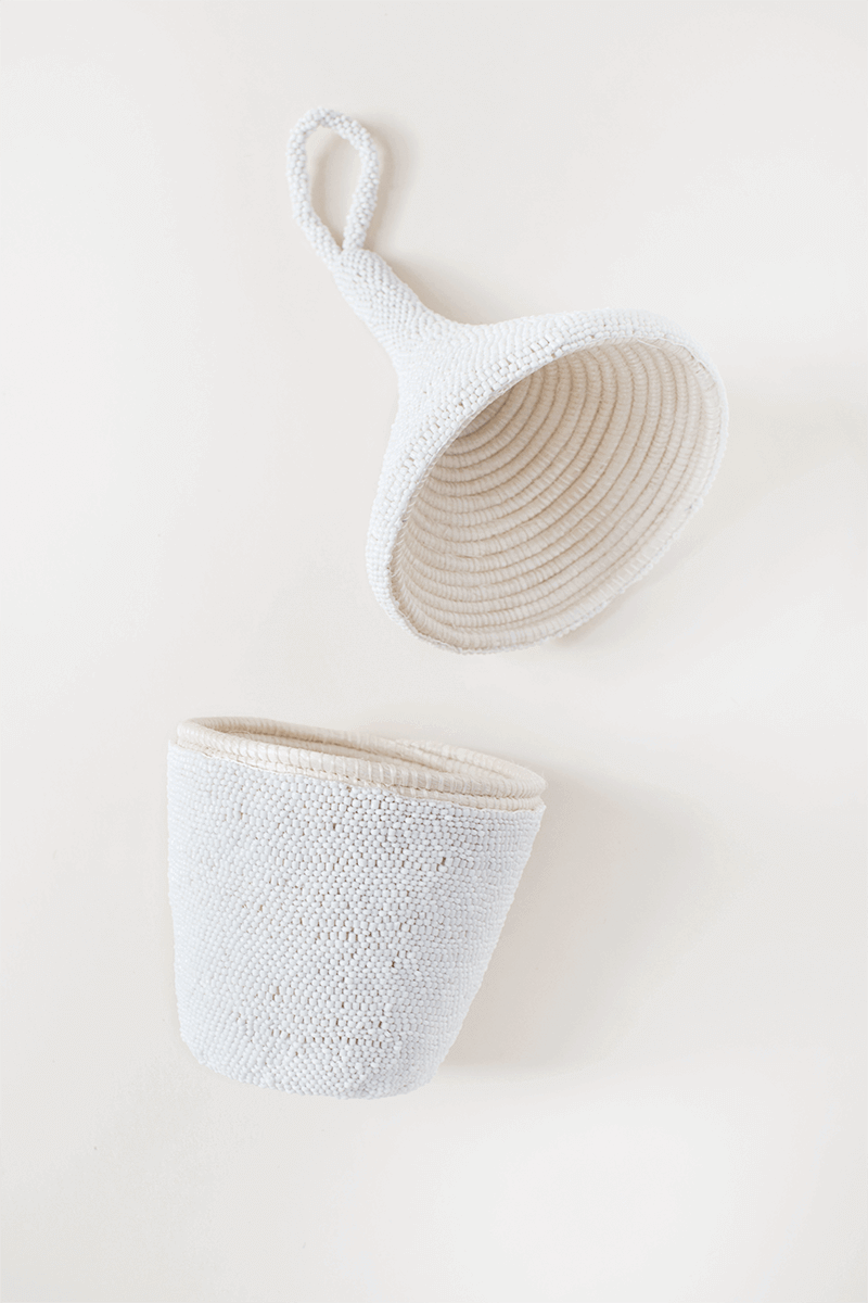 Two woven baskets, one white and one beige, on a light background
