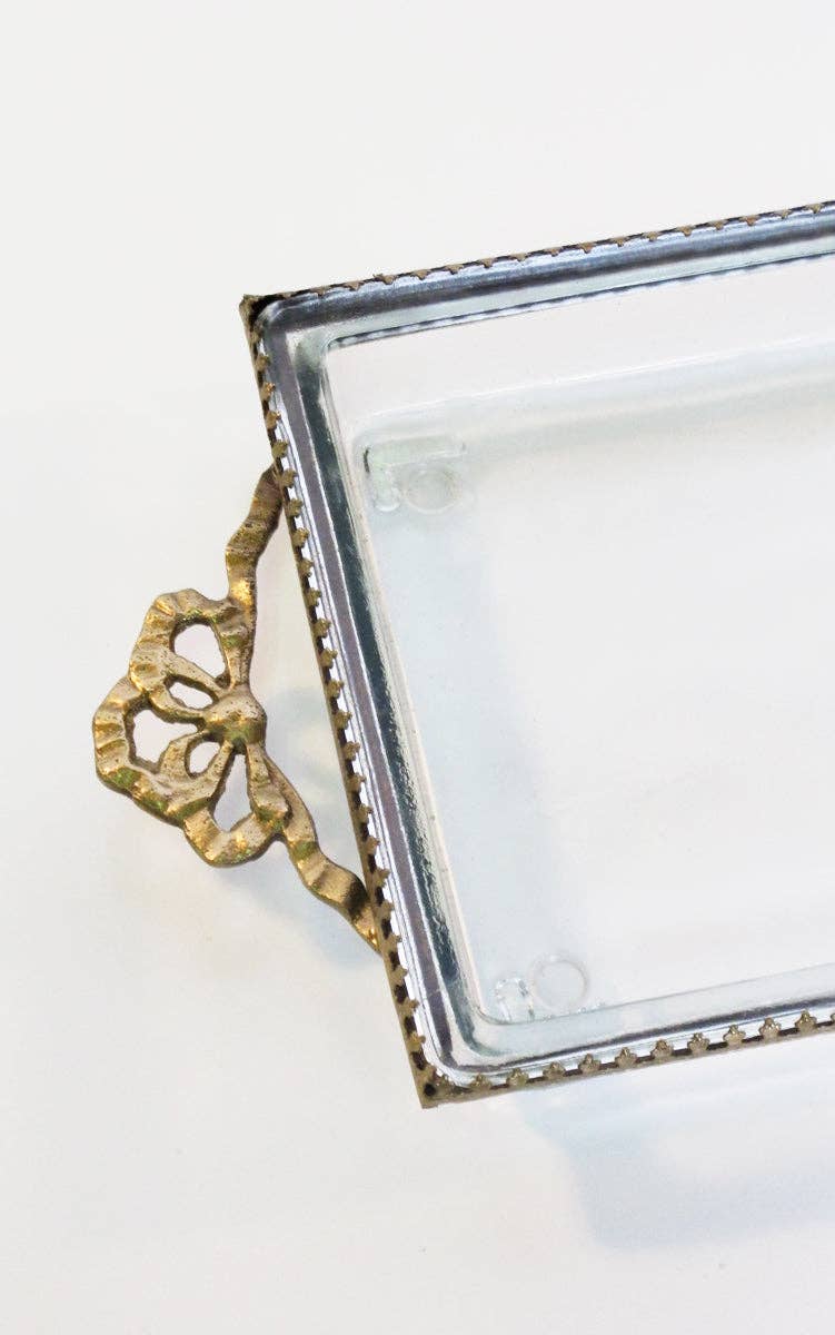 Decorative glass tray with gold handle on a white background