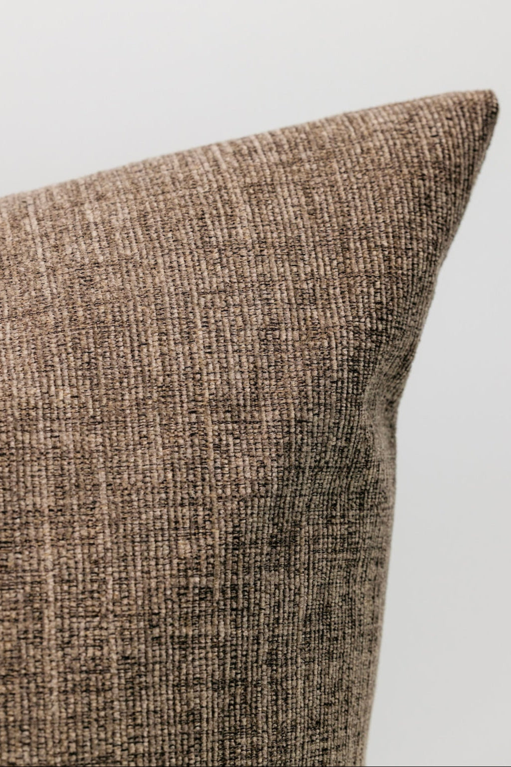 Textured brown pillow on a light gray background