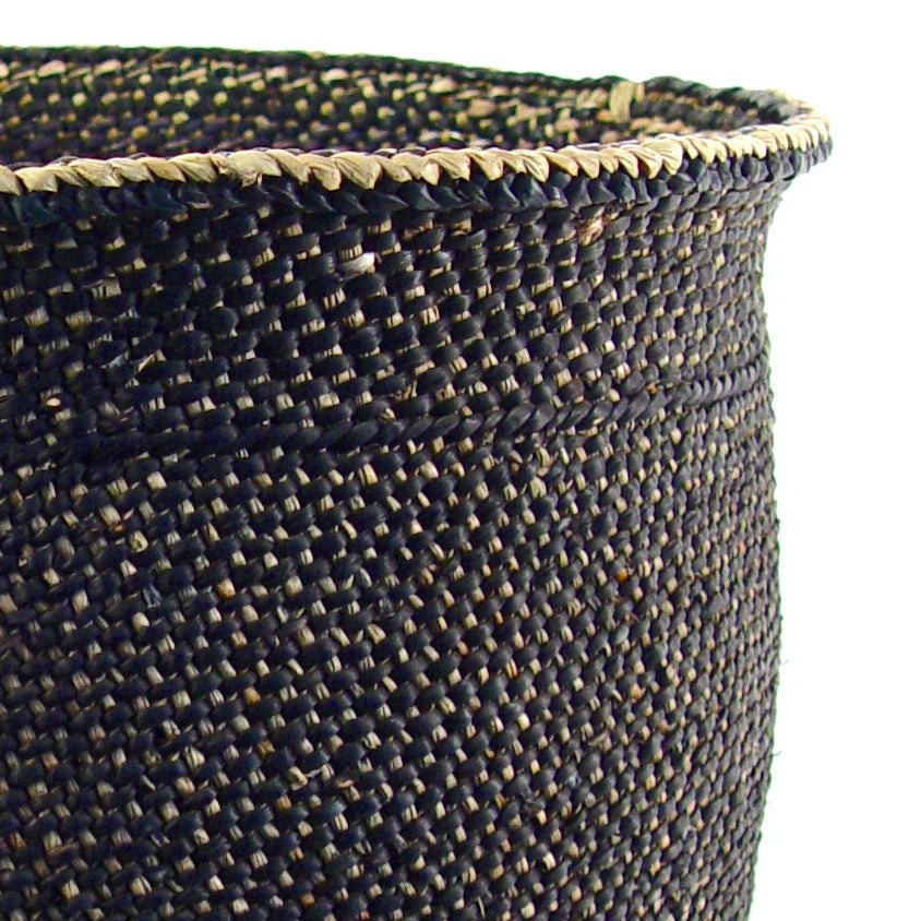 Close-up of a woven black basket with a white background