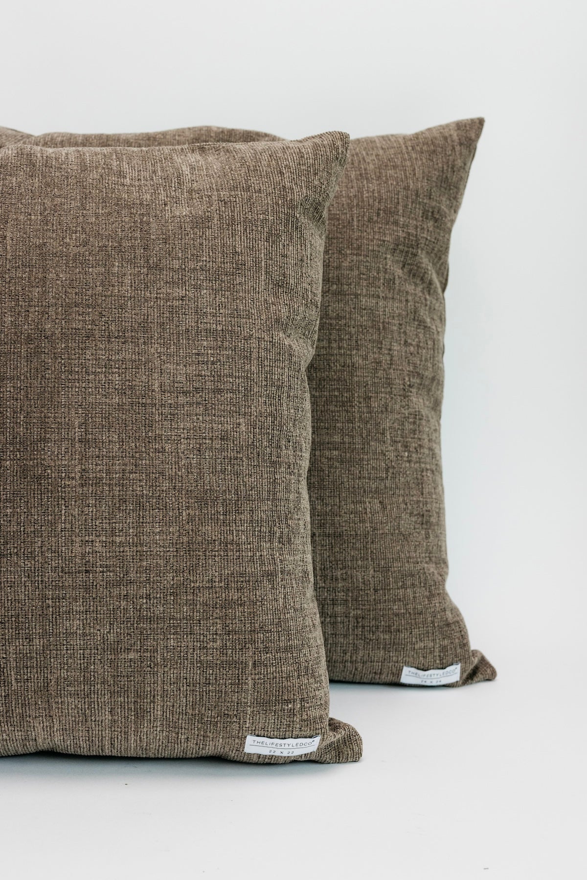 Two brown textured pillows on a white background