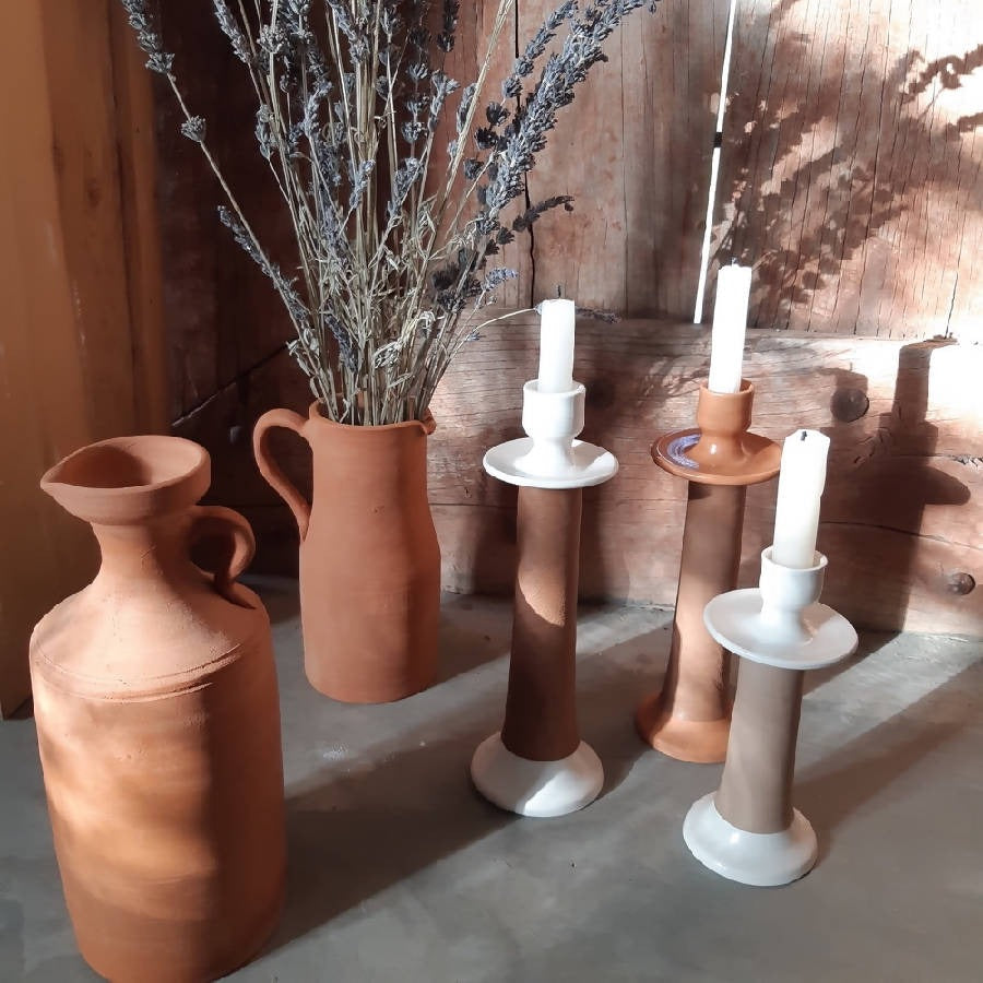 Terracotta vases and candle holders on a wooden surface