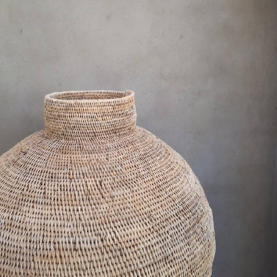 Woven rattan vase against a gray wall