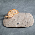 Marble cutting board with a slice of bread on a gray background