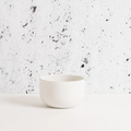 White ceramic cup on a speckled gray and white background