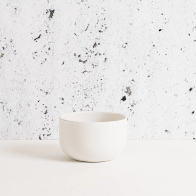 White ceramic cup on a speckled gray and white background