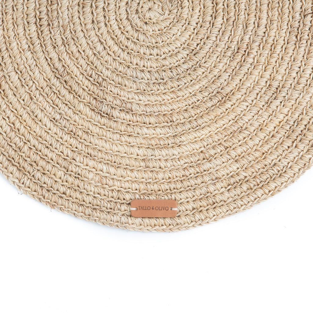 Round woven placemat with a brand label on a white background