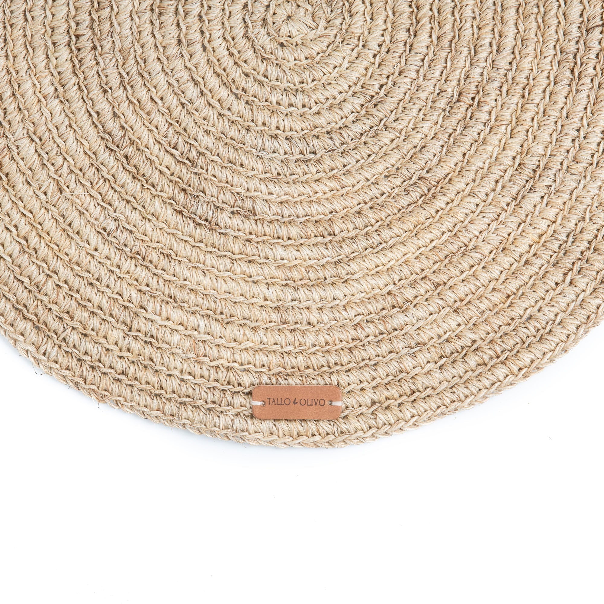 Round woven placemat with a brand label on a white background
