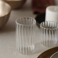 Clear glass tumblers with ribbed design on a neutral surface