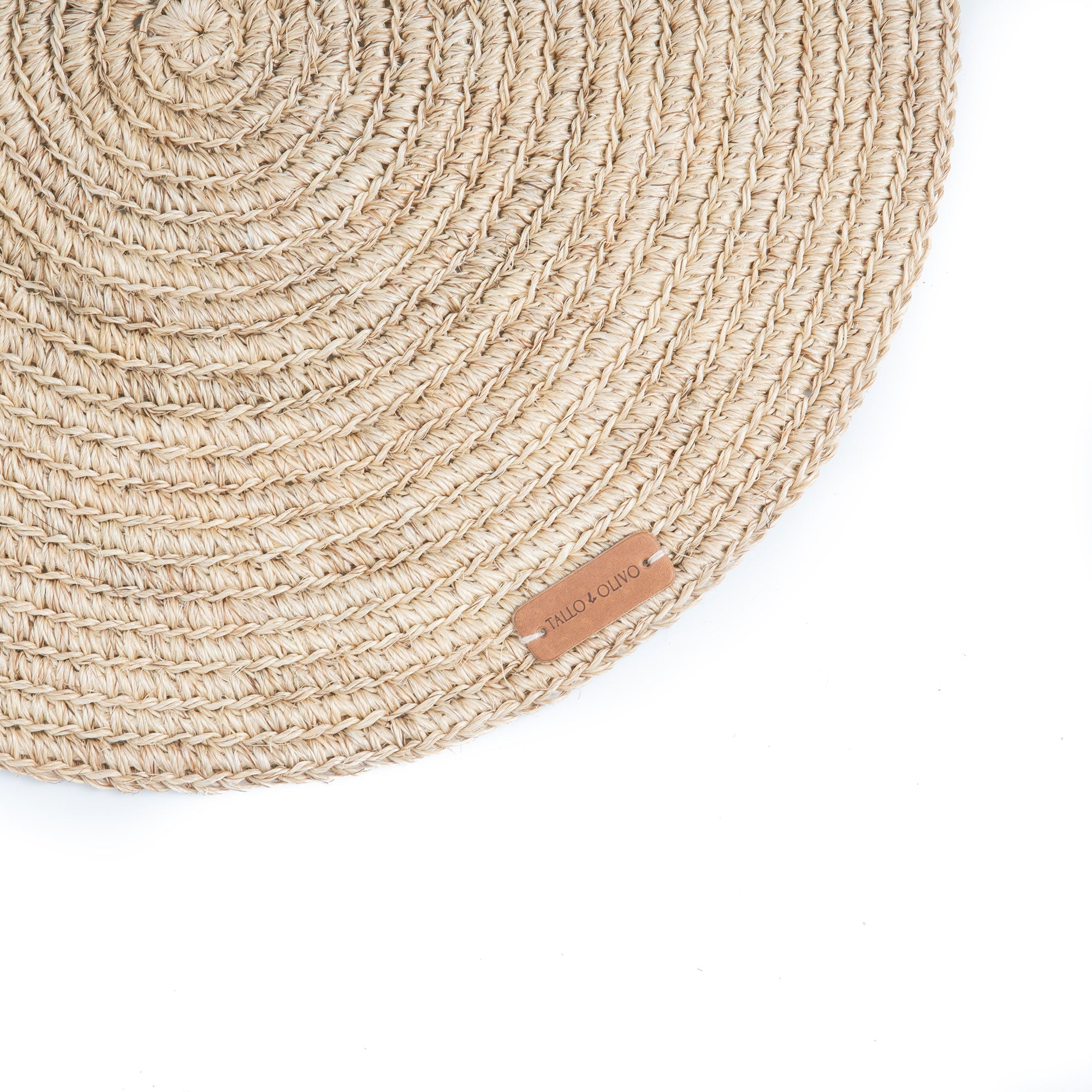 Round woven mat with a brand tag on a white background