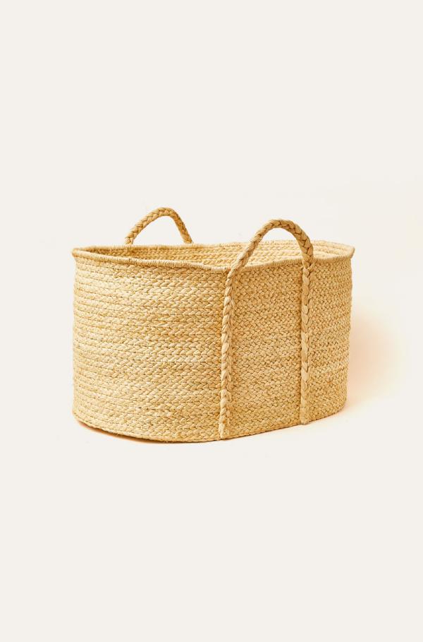 Woven basket with handles on a light beige background