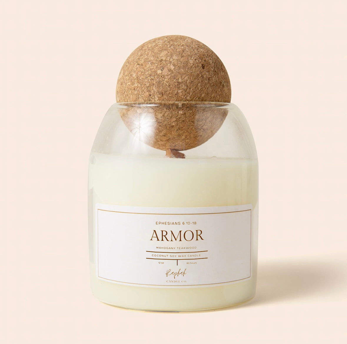A glass jar candle with pale cream wax and a round cork stopper, featuring a white label that reads 'ARMOR' and 'EPHESAIS 9:28-17:28'.