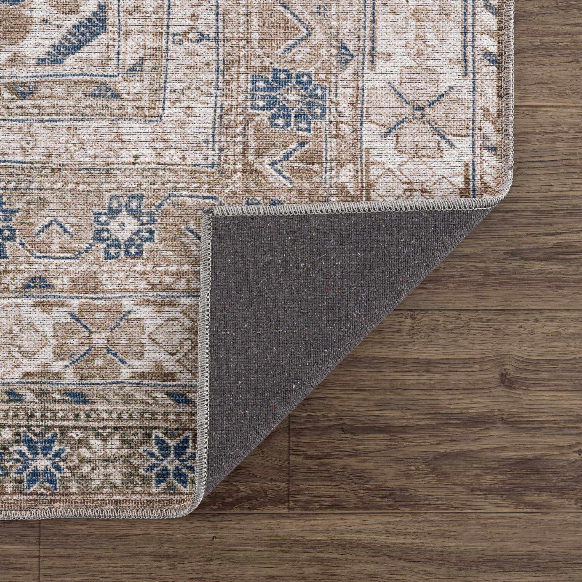Patterned rug with a gray border on a wooden floor