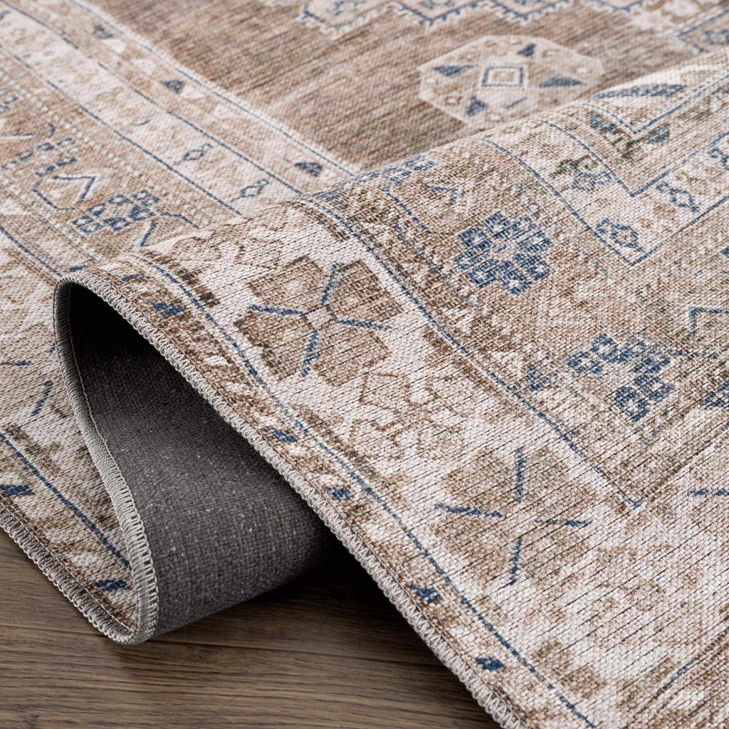 Close-up of a patterned rug with geometric designs on a wooden floor.
