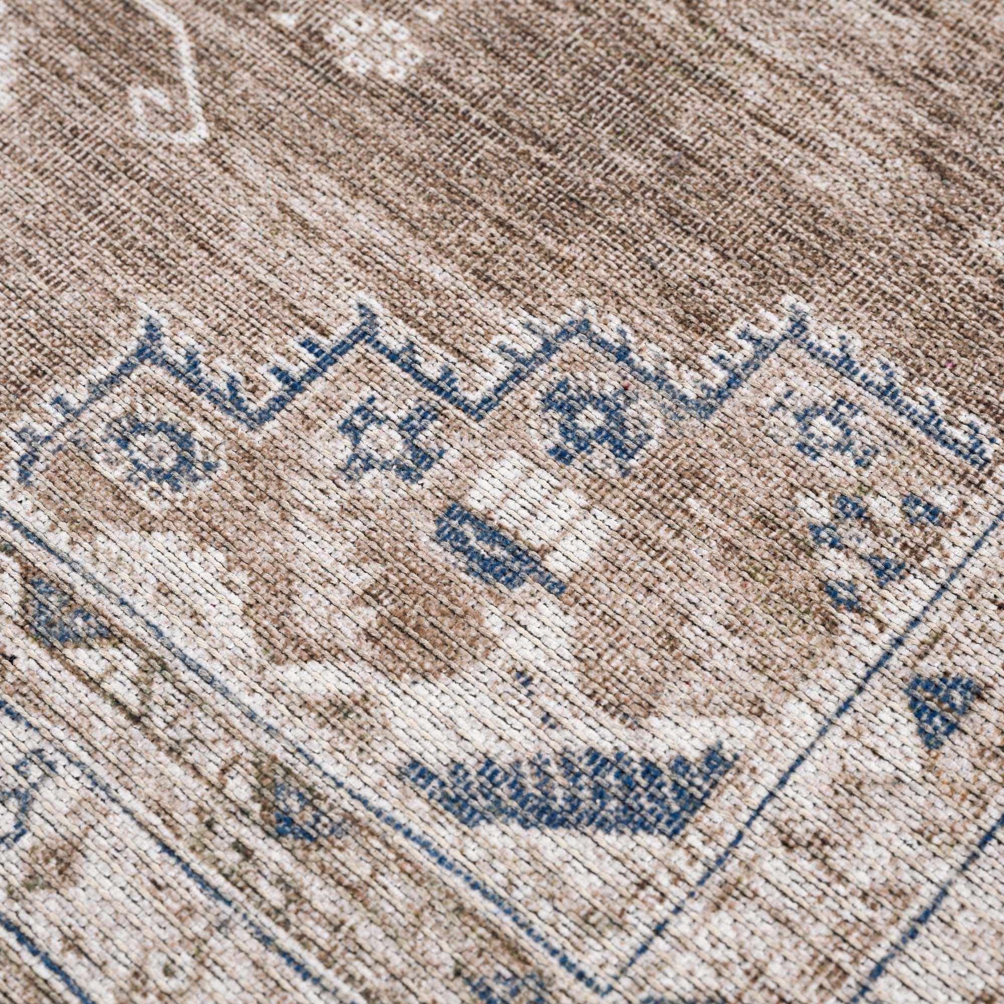 Close-up of a patterned rug with blue and beige colors