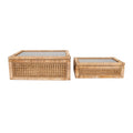 Two woven rattan boxes with glass lids on a white background