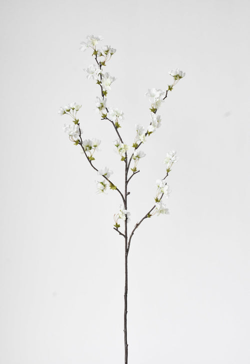 Artificial white flower branch on a light gray background