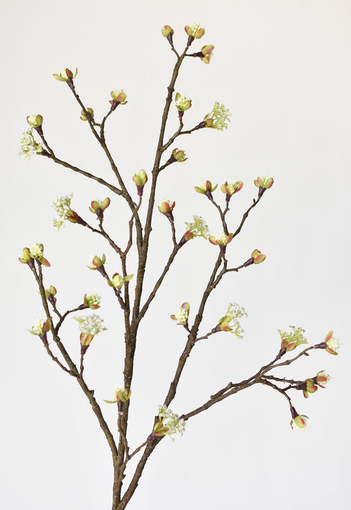Artificial branch with green buds on a light gray background