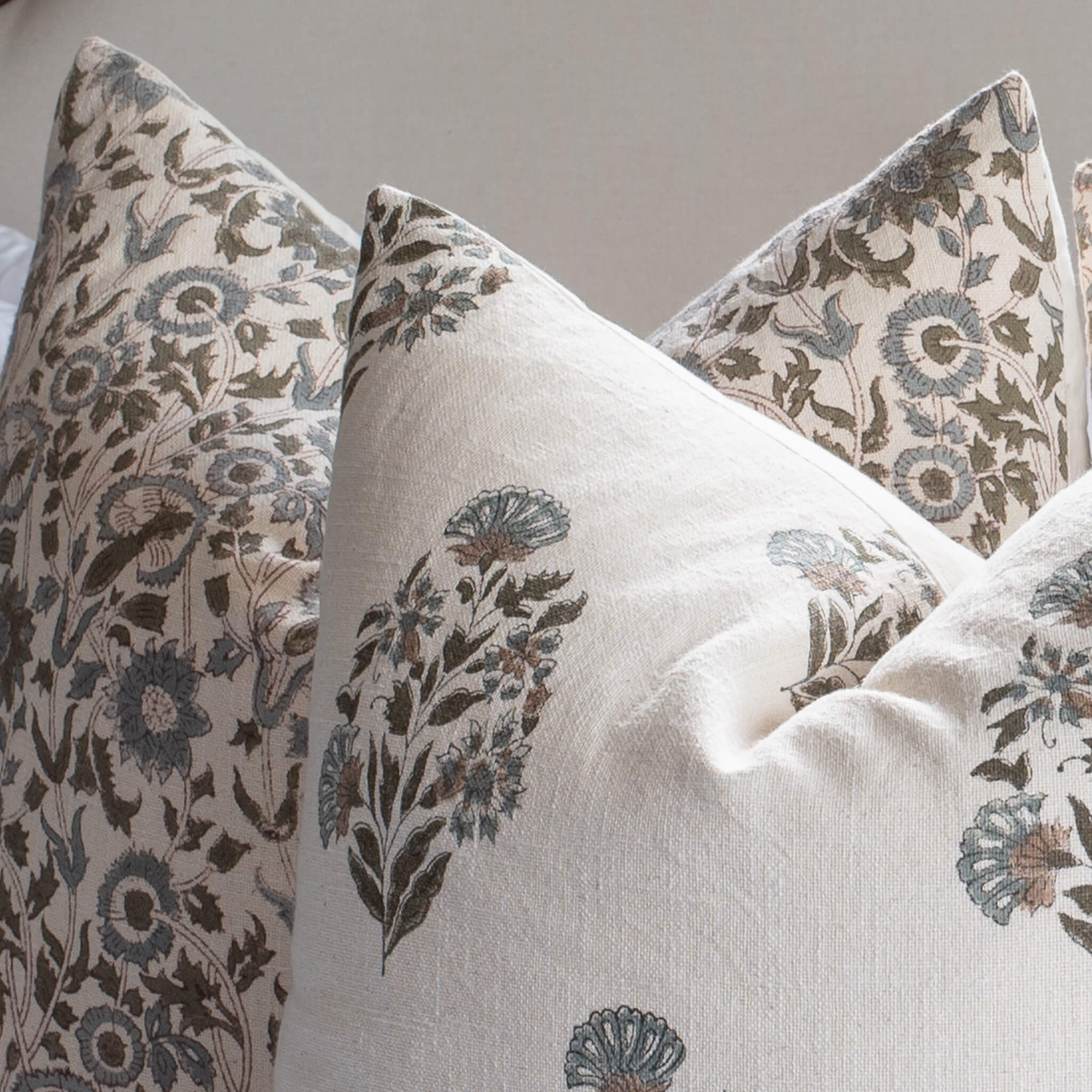 Decorative pillows with floral patterns on a neutral background