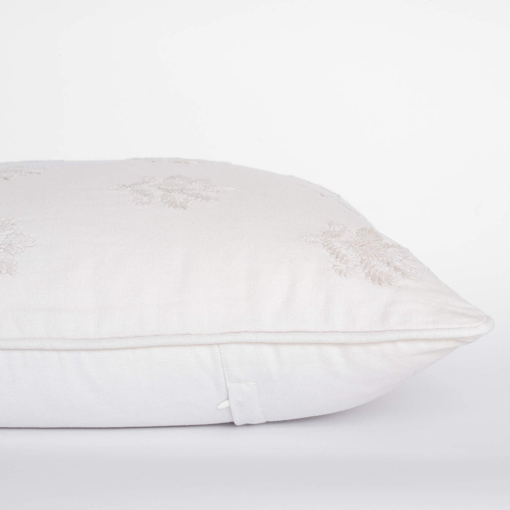 White pillow with lace trim on a white background