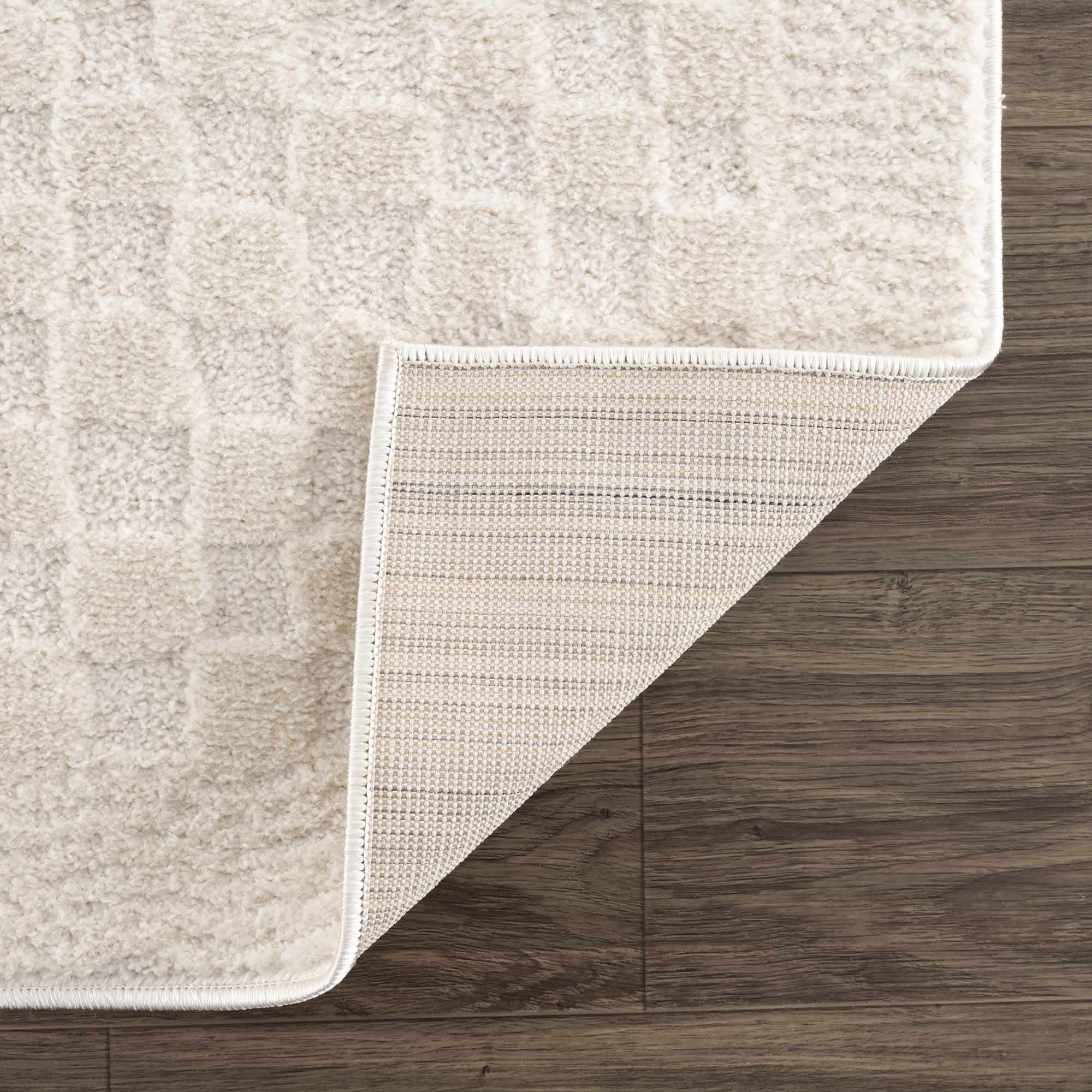 Beige rug corner on a wooden floor