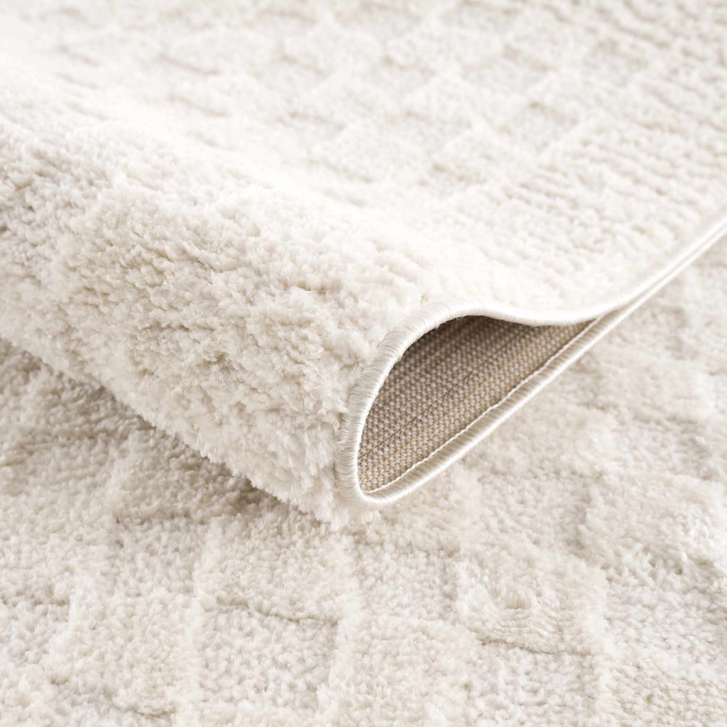 Close-up of a textured beige fabric with a focus on the weave pattern.
