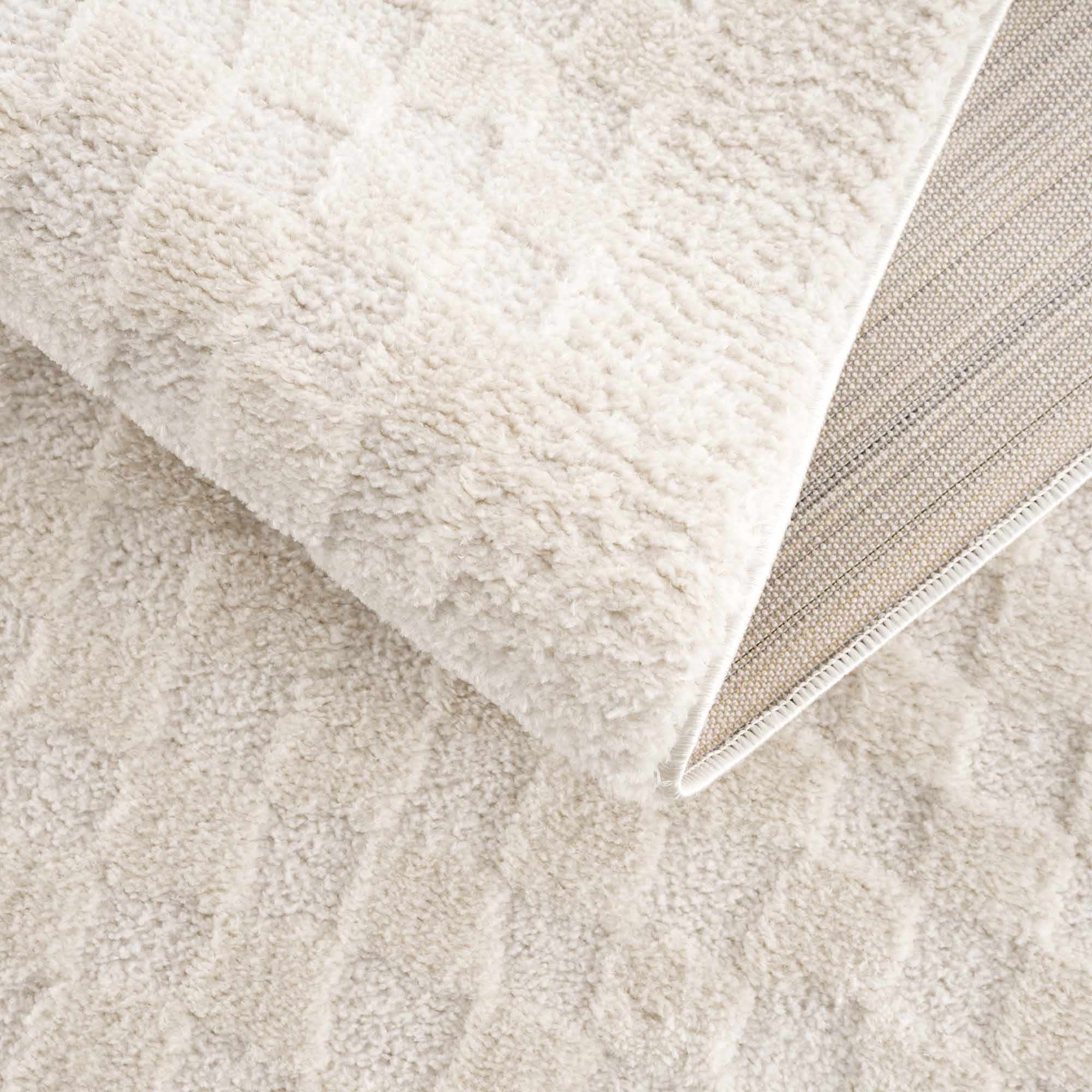 Close-up of beige textured fabric with a folded corner