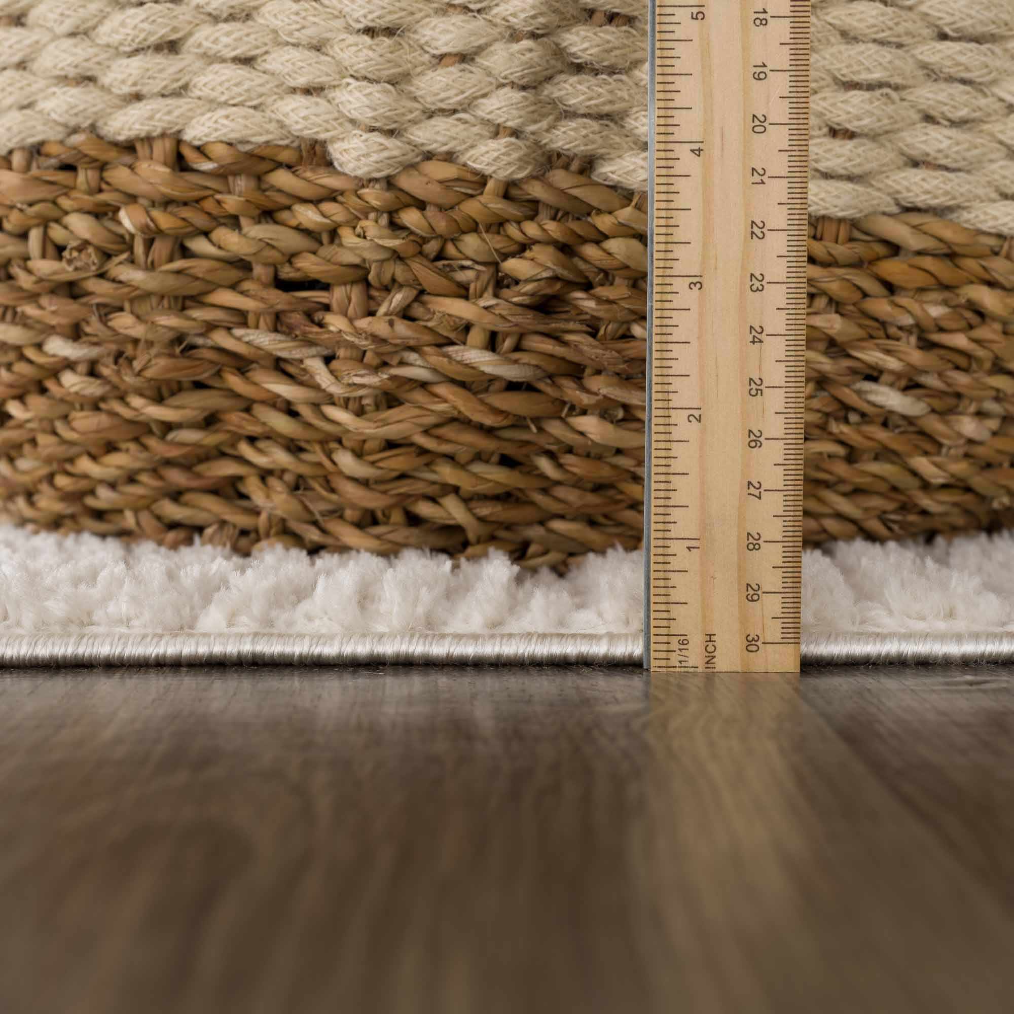 Rug with a woven texture and a ruler for scale on a wooden floor.