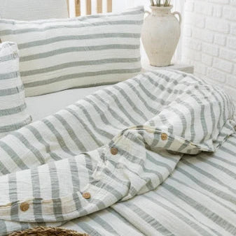 Striped bedding with pillows on a bed in a bedroom setting.