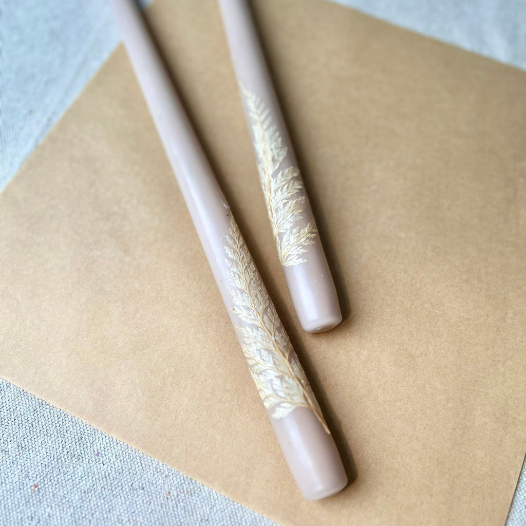 Two decorative pens with lace-like patterns on a beige surface.