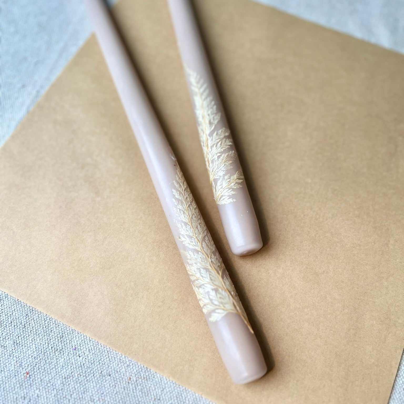 Two decorative pens with lace-like patterns on a beige surface.