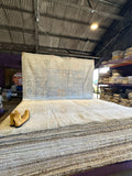 Large roll of carpet in a warehouse setting with a pair of boots on top.