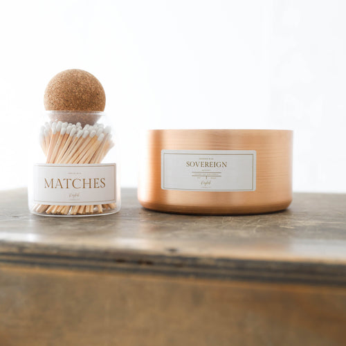 Candle and matchbox set on a wooden surface with a white background
