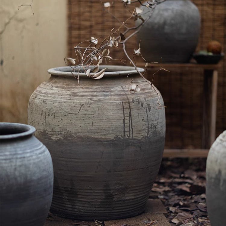 Decorative terracotta pots with a rustic finish on a wooden surface.