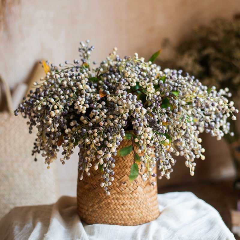 Bouquet of dried flowers in a woven basket on a neutral background