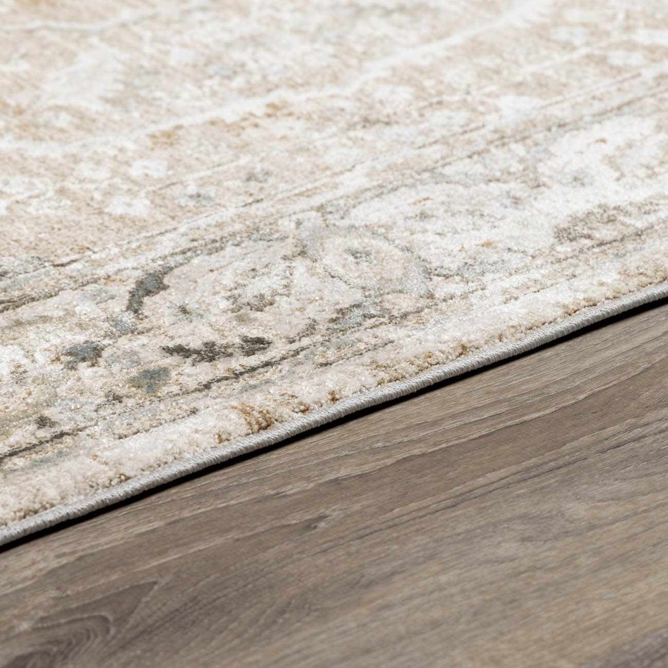 Close-up of a textured rug transitioning to a wooden floor.