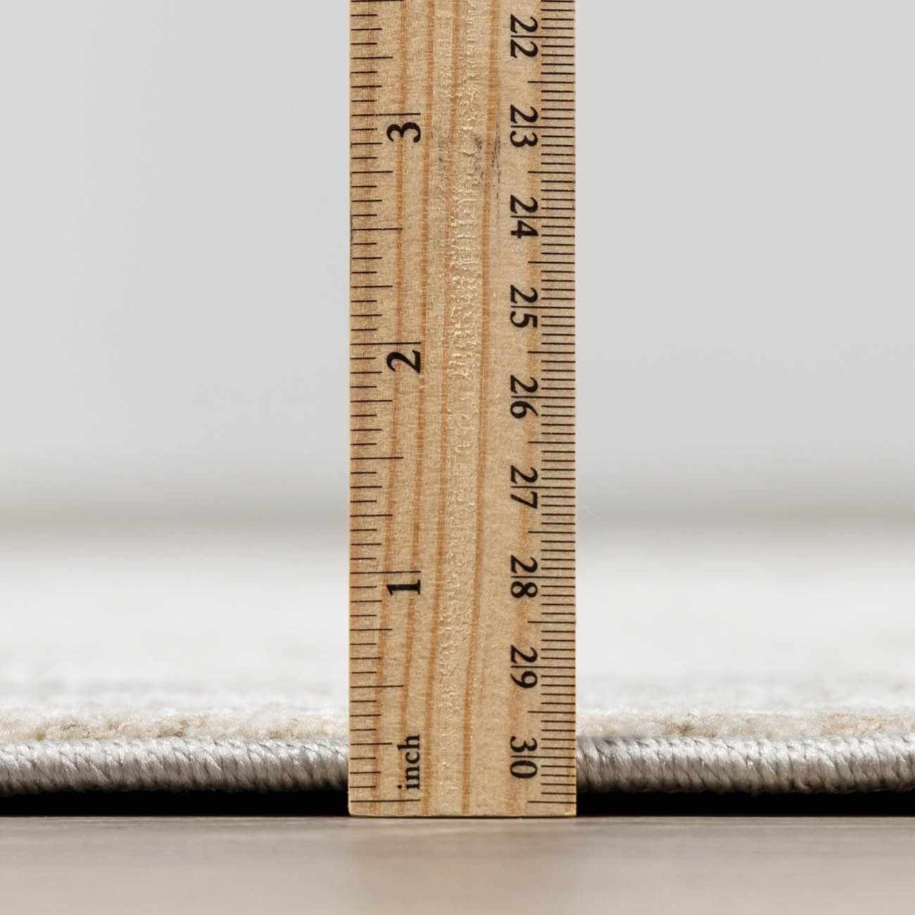 Wooden ruler on a carpet with a neutral background