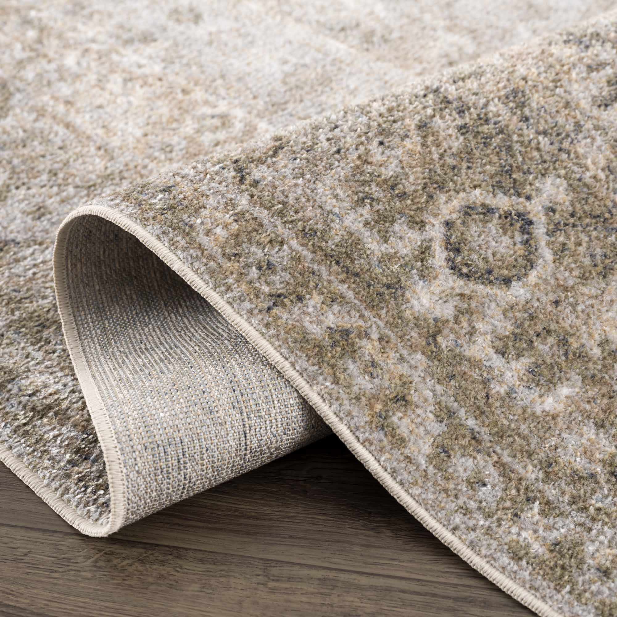 Close-up of a textured beige rug with a subtle pattern on a wooden floor.