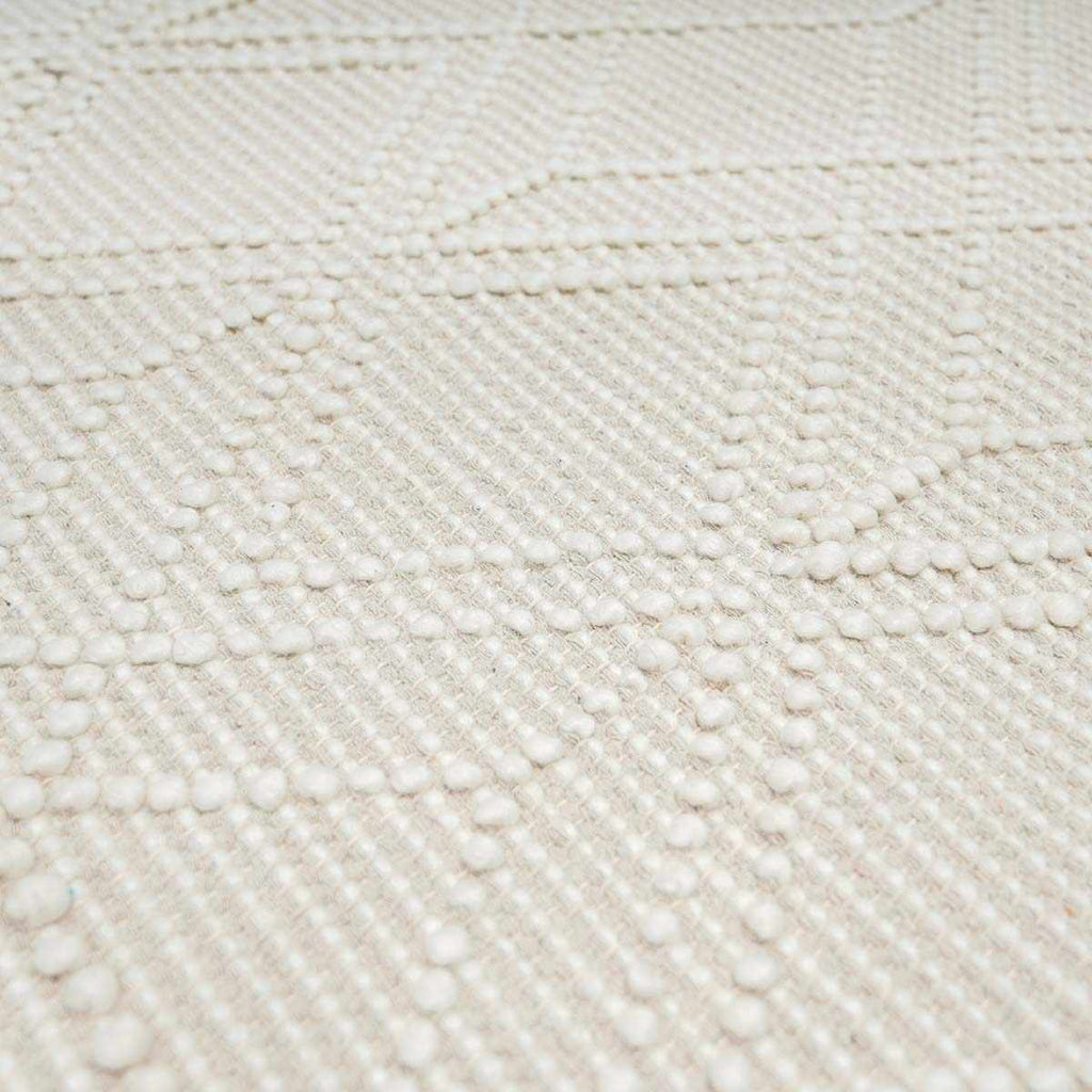 Close-up of a textured beige fabric with a diamond pattern