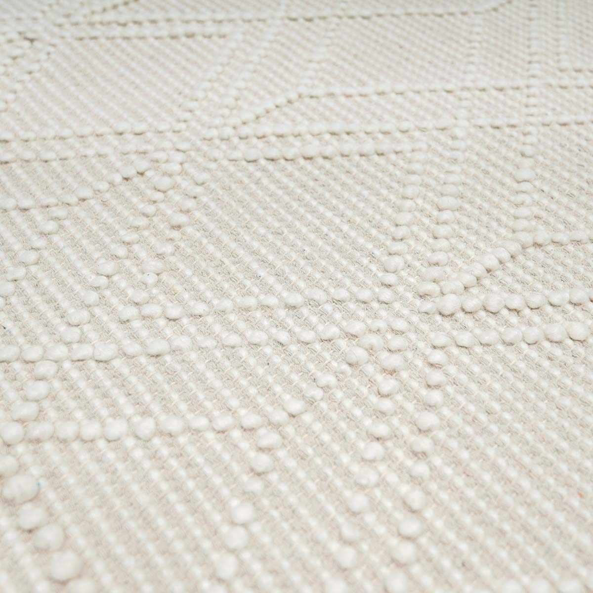 Close-up of a textured beige fabric with a diamond pattern