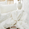 Lightweight white linen bedding with airy layered textures and soft neutral styling in a bright European-inspired bedroom. | Sorelle Rossi Shoppe