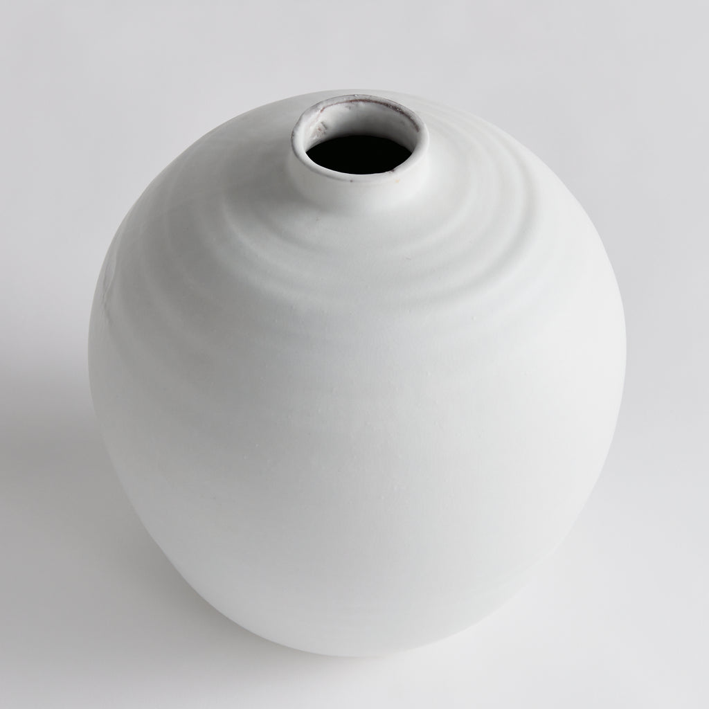 White ceramic vase on a light gray background