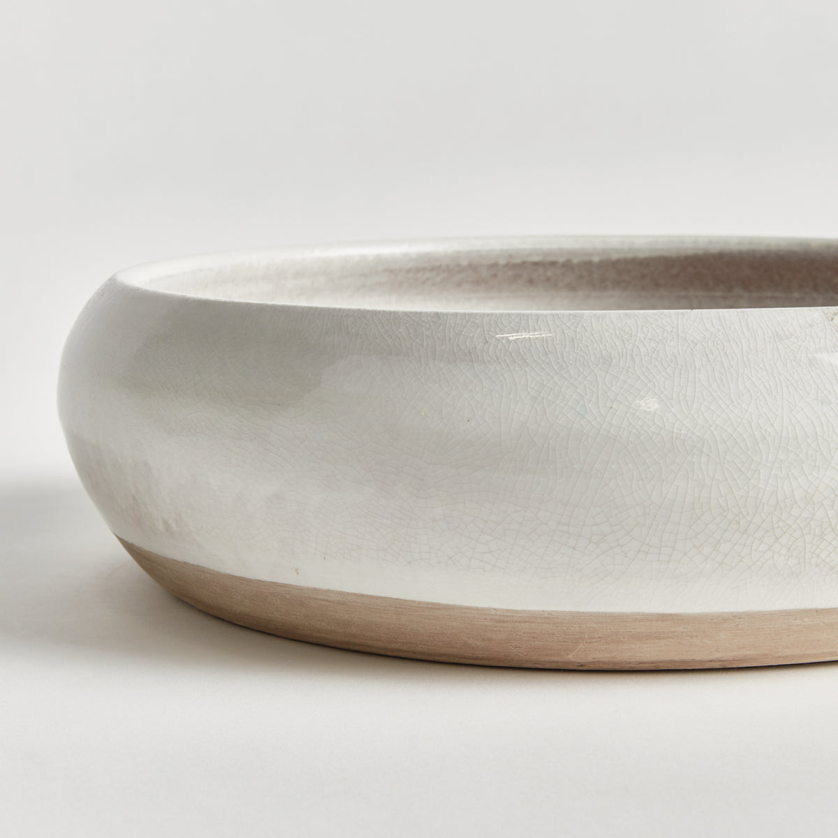 White ceramic bowl with wooden base on a light gray background