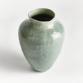 Green ceramic vase on a white background