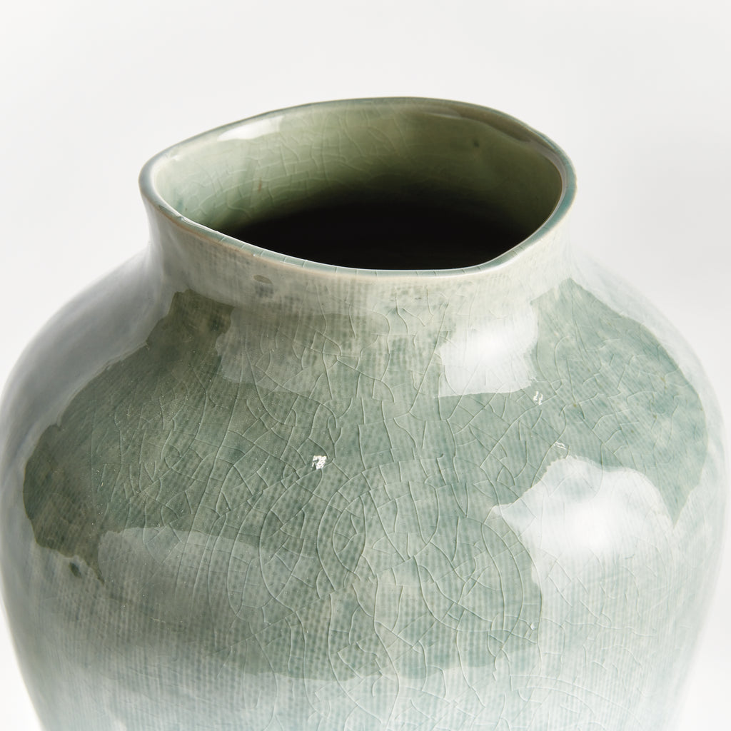 Green ceramic vase on a white background