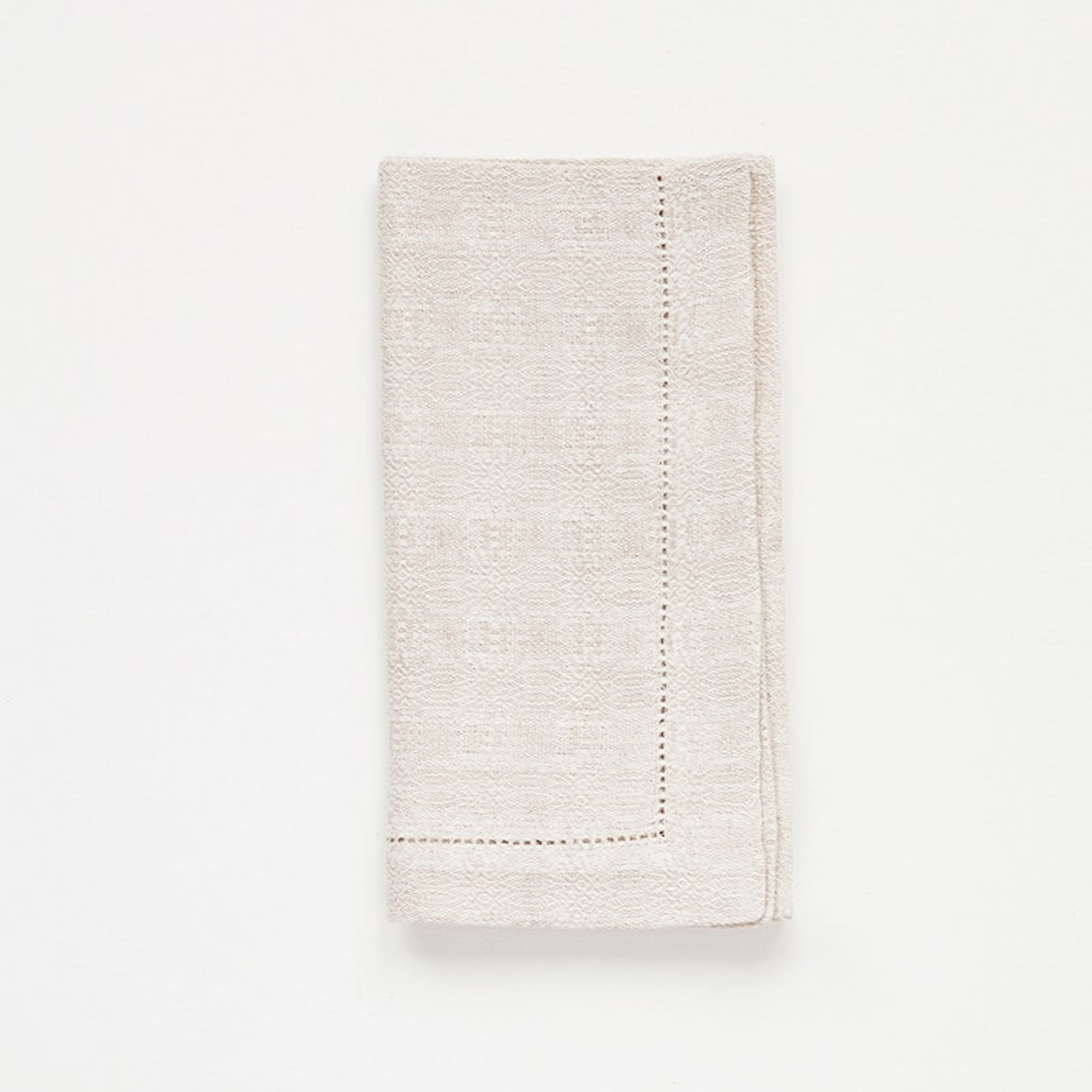 Folded beige napkin on a white background