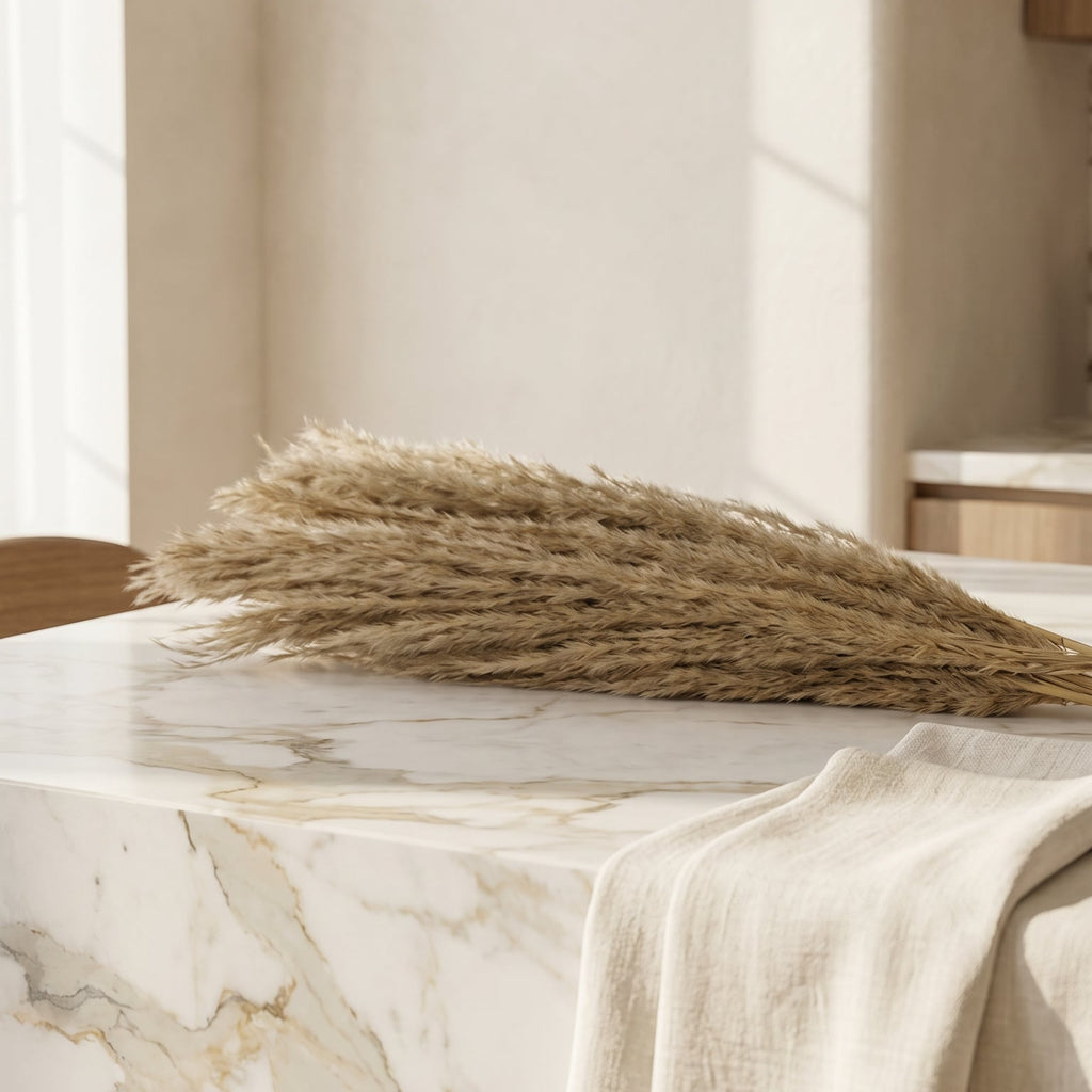 Decorative arrangement of dried grasses on a marble surface with a neutral background