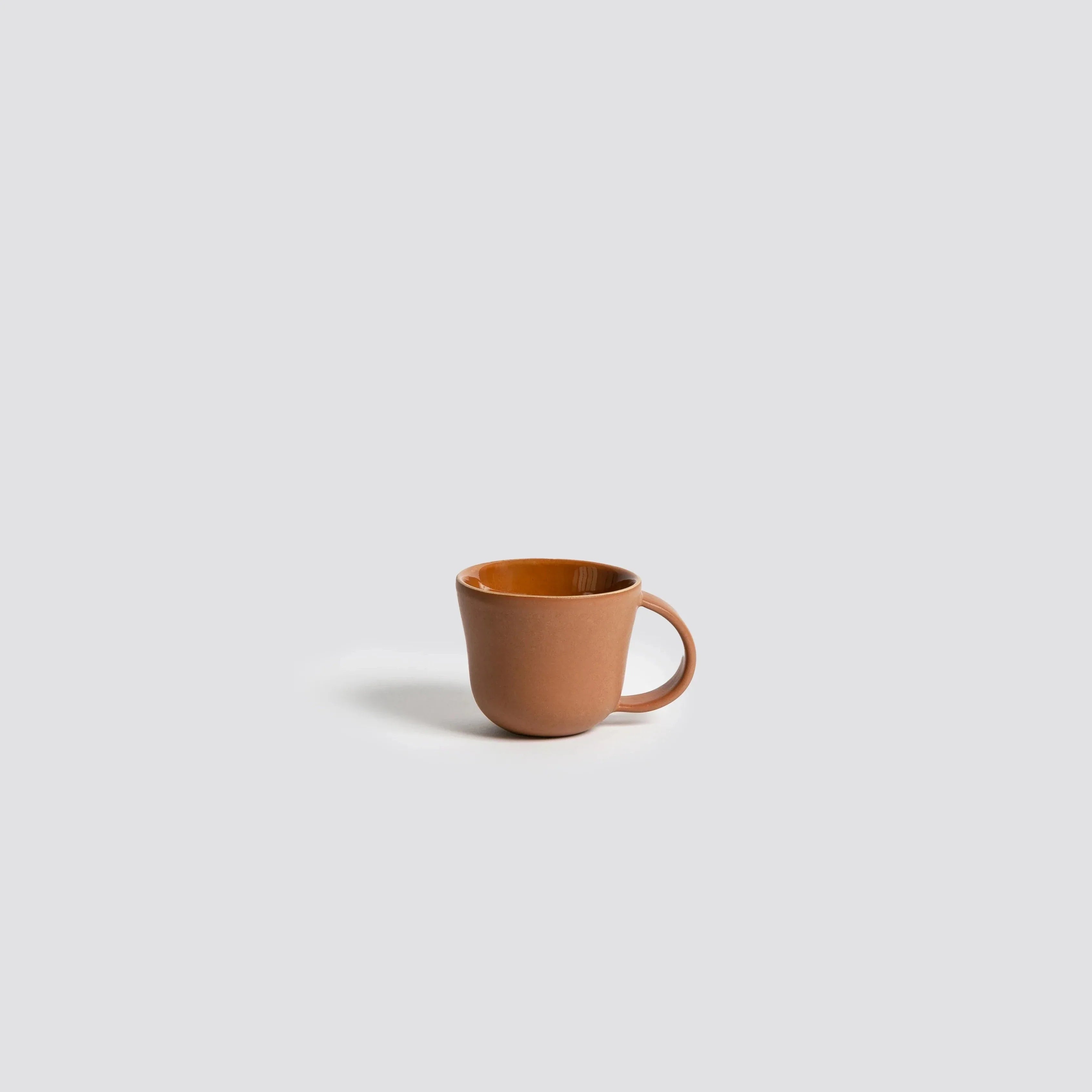 Brown ceramic mug on a light gray background