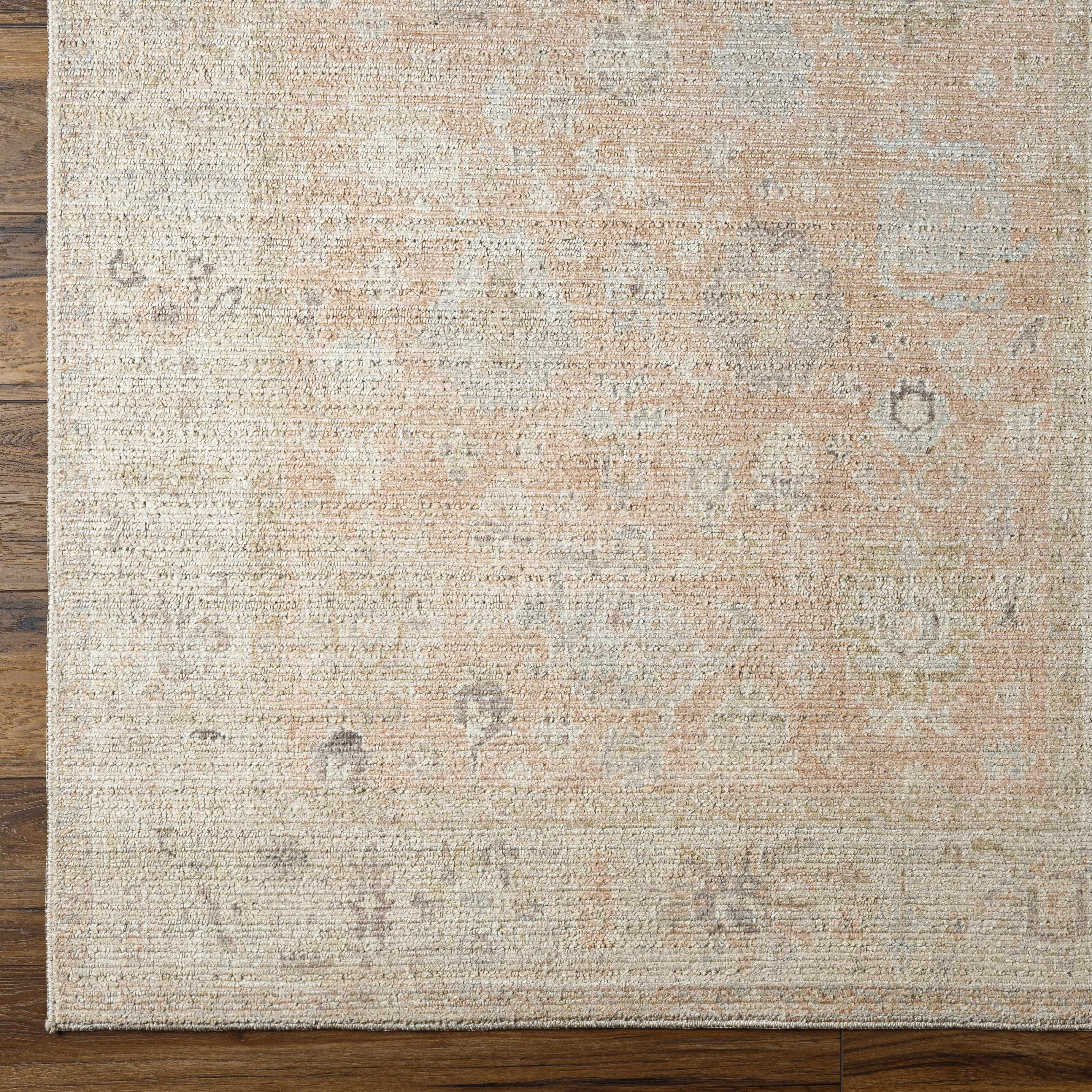 Textured area rug with a neutral color palette on a wooden floor.